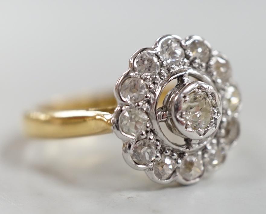 An 18ct and illusion set diamond circular cluster ring, size N, gross weight 5.1 grams.